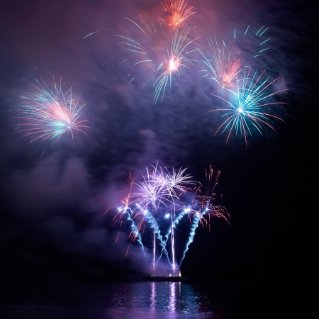 Colorful holiday fireworks on the black sky background の写真素材