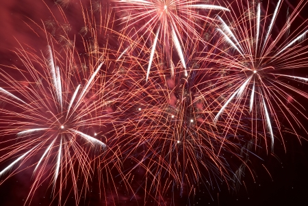 Red colorful holiday fireworks on the black sky background.の写真素材