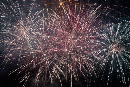Red colorful holiday fireworks on the black sky background.の写真素材