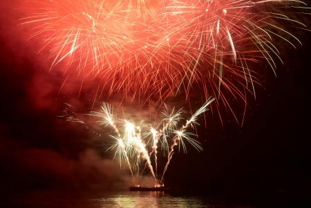 Red colorful holiday fireworks on the black sky background.の写真素材
