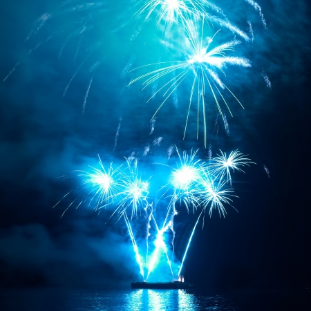 Blue colorful holiday fireworks on the black sky background.の写真素材