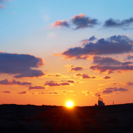Romantic sky with sun, beautiful blue, red and yellow clouds.の写真素材