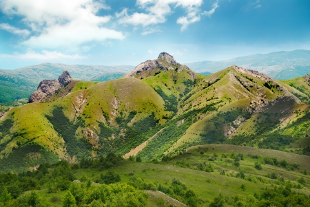 Green mountain covered with forest on the blue sky backgroundの写真素材
