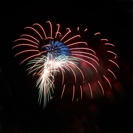 Blue and red colorful holiday fireworks on the black sky background.の写真素材