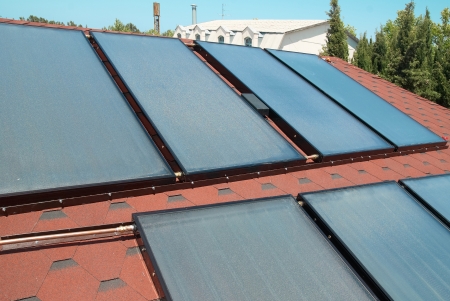 Solar water heating panels on the red roof. Gelio systemの写真素材