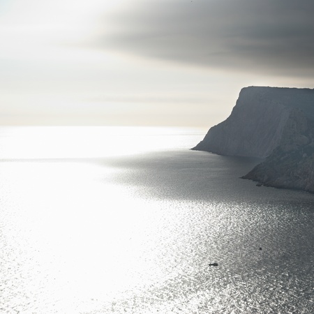 Calm seascape with stormy sky. Silver sea and the mountainsの写真素材