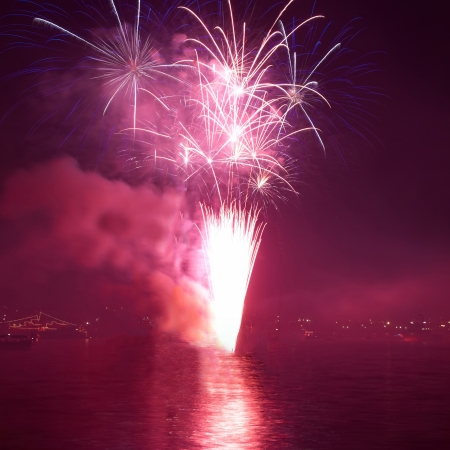 Red colorful holiday fireworks on the black sky background.の写真素材