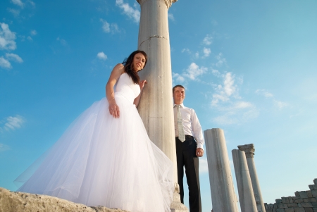 Beautiful wedding couple- bride and groom near greece column in the ancient cityの写真素材