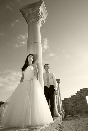 Beautiful wedding couple- bride and groom near greece column in the ancient city. Black and white, sepiaの写真素材