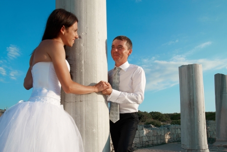 Beautiful wedding couple- bride and groom near greece column in the ancient cityの写真素材