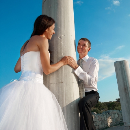 Beautiful wedding couple- bride and groom near greece column in the ancient cityの写真素材