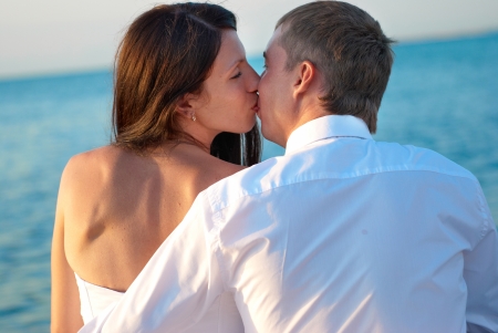 Beautiful wedding couple- bride and groom kissing at the beach. Just marriedの写真素材