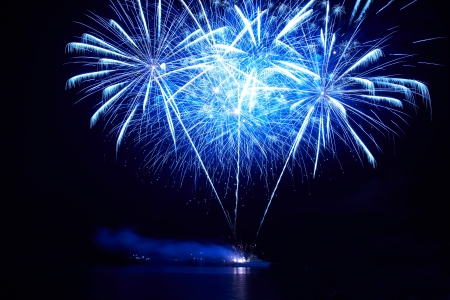 Blue colorful fireworks on the black sky backgroundの写真素材