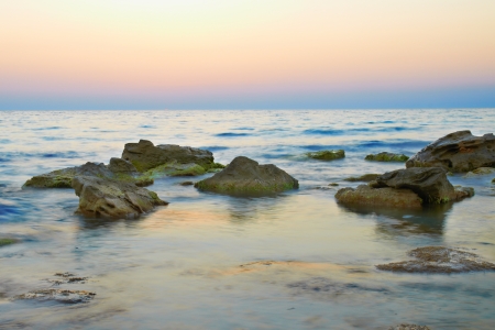 Rocks in the sea against beautiful sunsetの写真素材