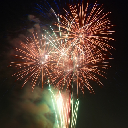 Red colorful holiday fireworks on the black sky background.の写真素材