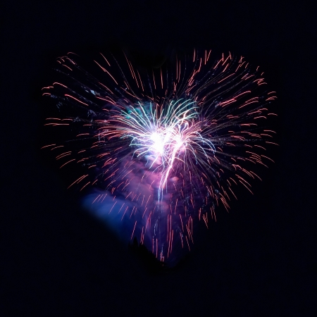 Heart fireworks on the black sky backgroundの写真素材