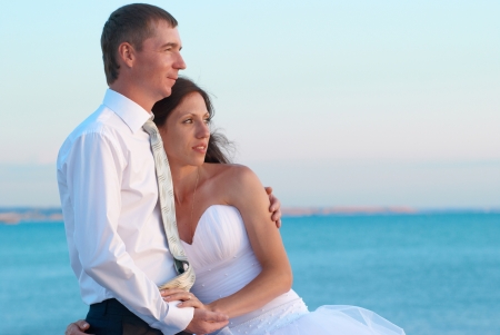 Beautiful wedding couple- bride and groom hugging at the beach. Just marriedの写真素材