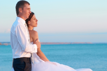 Beautiful wedding couple- bride and groom hugging at the beach. Just marriedの写真素材