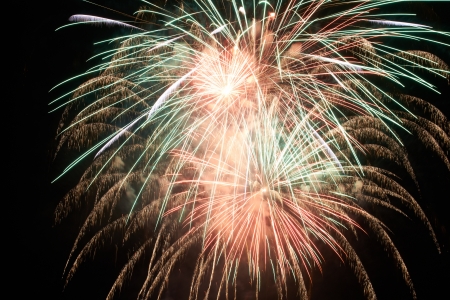 Red colorful holiday fireworks on the black sky background.の写真素材