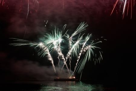 Colorful holiday fireworks on the black sky background の写真素材