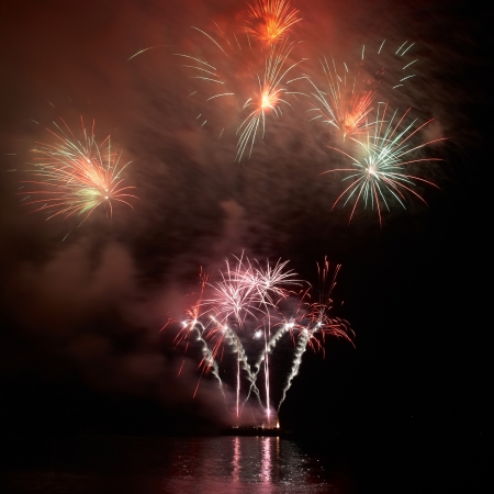 Colorful holiday fireworks on the black sky background.の写真素材
