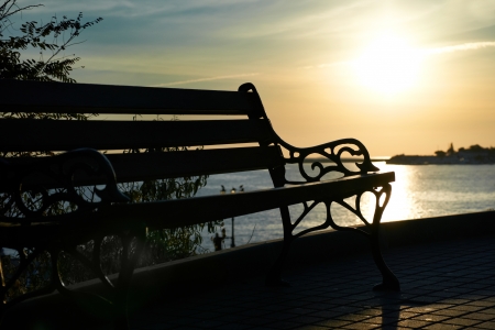 Bench near the sea against beautiful sunsetの写真素材