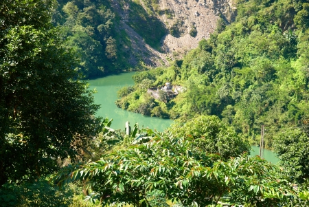 River and indian temple in the forest surrounded by green treesの写真素材