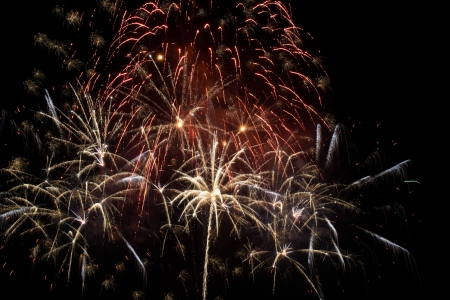 Red colorful holiday fireworks on the black sky background.の写真素材