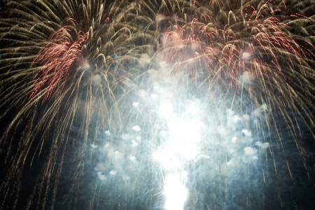 Red colorful holiday fireworks on the black sky background.の写真素材