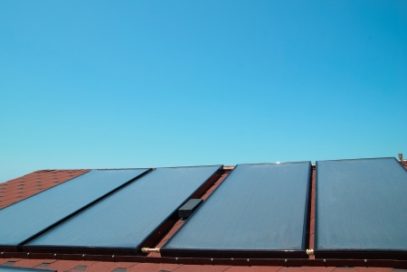 Solar water heating panels on the red roof. Gelio systemの写真素材