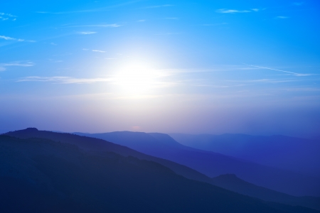 Beautiful sunset at the mountains. Colorful landscape with sun and blue skyの写真素材
