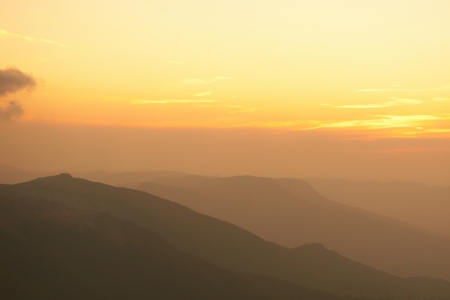 Beautiful sunset at the mountains. Colorful landscape with sun and orange skyの写真素材