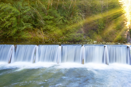 Waterfall cascade streaming down in the green sunny forestの写真素材