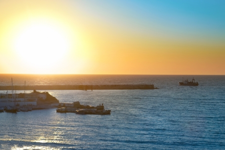 Boat and beautiful red sunset above the seaの写真素材