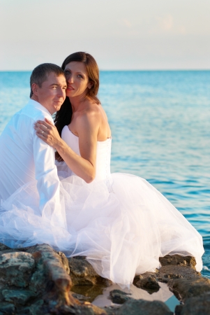 Beautiful wedding couple- bride and groom hugging at the beach. Just marriedの写真素材