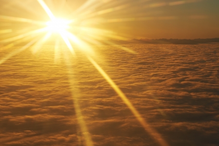 Amazing view from plane on the orange sky, sunset sun and cloudsの写真素材