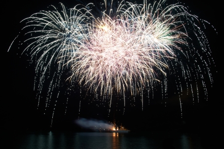 Red and purple colorful holiday fireworks on the black sky background.