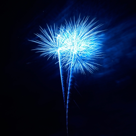 Blue colorful fireworks on the black sky backgroundの写真素材