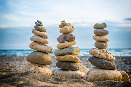 Three stacks of round smooth stones on the beach