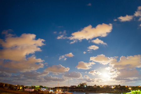 Night scene and sunset with blue clouds, sun and stars の写真素材