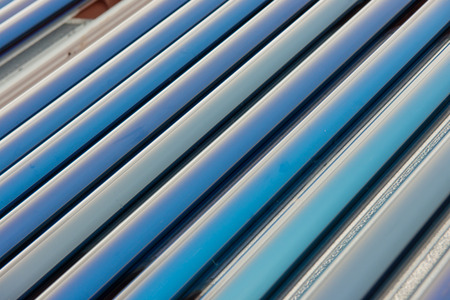 Vacuum collectors- solar water heating system on red roof of the house の写真素材