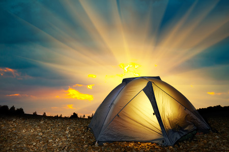 Illuminated yellow camping tent under stars at night. の写真素材