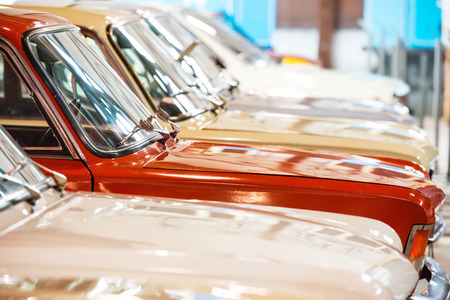Red and white cars in a row on parking lotの写真素材