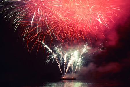 Red colorful holiday fireworks on the black sky background.の写真素材