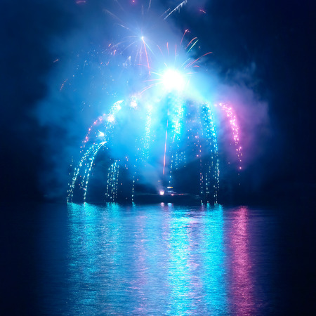 Blue colorful fireworks on the black sky background. Holiday celebration.の写真素材