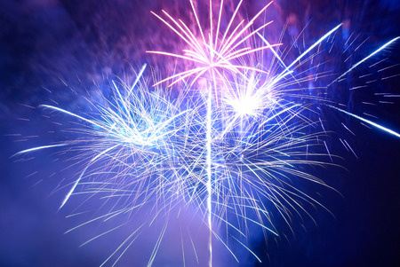 Blue and purple colorful fireworks on the black sky background. Holiday celebration.の写真素材