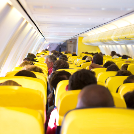 Aisle inside a plane. Interior with passengers on the seatsの写真素材