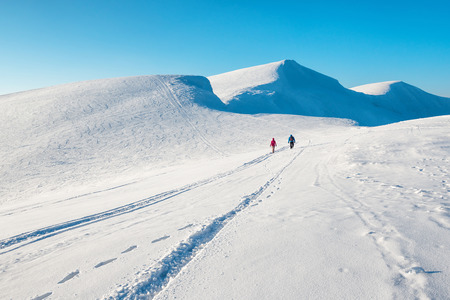 Two people in beautiful winter mountains. Snow landscapeの写真素材