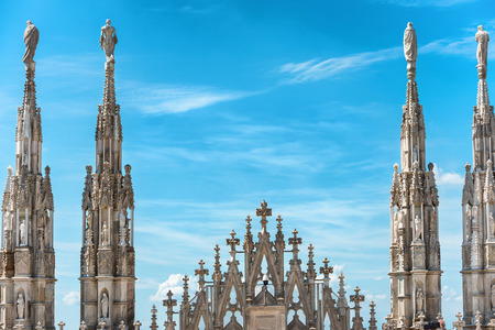 White marble statues on the roof of famous Cathedral Duomo di Milano on piazza in Milan, Italyの写真素材
