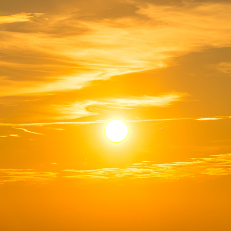 Sunset in the sky with orange clouds and big sunの写真素材